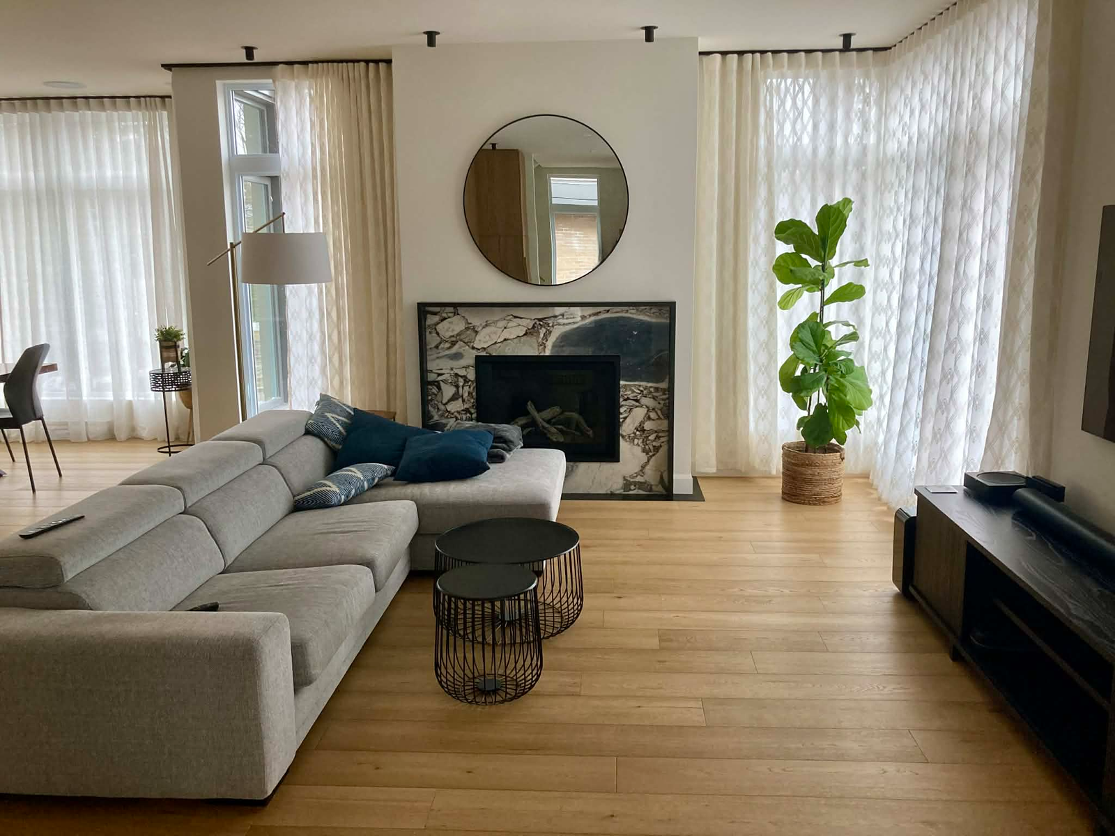 Réalisation Samuel Entrepreneur Général — Salon luxueux avec foyer en marbre, planchers de bois franc et grandes fenêtres