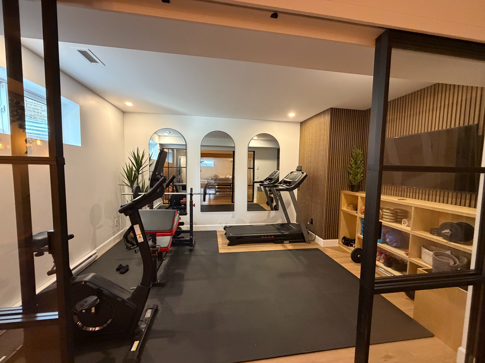 Sous-sol Beauport — Salle de gym avec cloison vitrée et mur de lattes